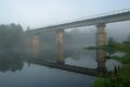 Old abandoned bridge over the river half-covered with predawn mist Royalty Free Stock Photo