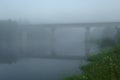 Old abandoned bridge over the river half-covered with predawn mist Royalty Free Stock Photo