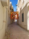 Marsa, Malta - May 2018: Festively decorated empty narrow street with banners for annual festa religious holiday in sunny day