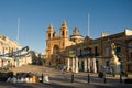 Marsaxlokk, Malta, August 2019. The main square of the village with the cathedral in the early morning. Royalty Free Stock Photo