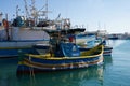 MARSAXLOKK, MALTA - DEC 31st, 2019: Marsaxlokk market with traditional Luzzu fishing boats on a beautiful winter day Royalty Free Stock Photo