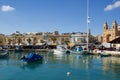 MARSAXLOKK, MALTA - DEC 31st, 2019: Marsaxlokk market with traditional Luzzu fishing boats on a beautiful winter day Royalty Free Stock Photo