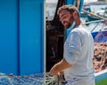 Smiling Fisherman arranging fishing net