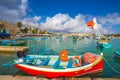 Marsaxlokk, Malta - Traditional colorful maltese Luzzu fisherboat at the old market of Marsaxlokk with turquoise sea water Royalty Free Stock Photo