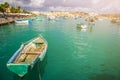 Marsaxlokk, Malta - Traditional colorful maltese Luzzu fisherboats at the old market of Marsaxlokk with green sea water Royalty Free Stock Photo