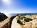 Marsaxlokk, Malta - 10-24-22 - Winding stone wall and walking path along the ocean