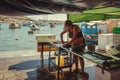 Woman cuts fish for customers on street bazaar of the fishing town