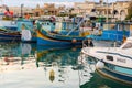 Traditional eyed colorful boats Luzzu in the Harbor of Mediterranean fishing village Marsaxlokk, Malta Royalty Free Stock Photo