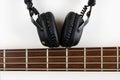 Marshall bluetooth headphones, wireless, and fretboard from bass guitar on white background