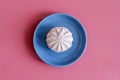 Marshmallow in a blue plate on a pink background. copy space Royalty Free Stock Photo