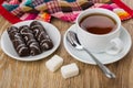 Marshmallow in chocolate in plate, cup of tea, sugar, teaspoon