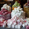 Marshmallow cube candies lie on shop window ready for sale. Heaps of pink, white, red, orange, green sweets in candy