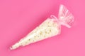 Marshmallow in a gift plastic bag on a pink background