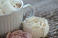 Marshmallow looks like rose close-up. cup with small marshmallows sprinkled with grated chocolate on cotton knitted napkin Royalty Free Stock Photo