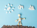 Marshmallow man with coffee beans and marshmallow clouds. Flat lay