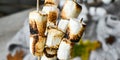 Marshmallow skewers Marshmallows On A Stick Roasting close up. White camping marshmallow. Sweater autumn background. Camping Fall