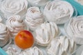 Marshmallows laid out on a tray. Nearby are ripe apricots