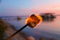 Marshmallow on fire during summer front lake Royalty Free Stock Photo