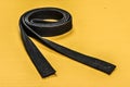 Martial art black belt isolated on yellow mat background