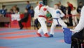 Martial art competitions - coach-judge with blue flag looking at karate teenager`s fighting