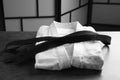 Martial arts uniform with black belt on grey stone table indoors