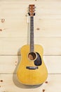 Martin guitar hanged against wood grain wall