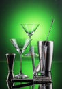 Martini Barware tools on reflective surface and green background