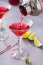 Martini cocktail with cranberry juice garnished with lime twist Royalty Free Stock Photo