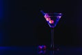 Martini cocktail drink splash with ice cubes in neon iridescent pink and blue colors. Minimal night party life concept. Royalty Free Stock Photo