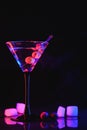 Martini cocktail drink splash with ice cubes in neon iridescent pink and blue colors. Minimal night party life concept. Royalty Free Stock Photo