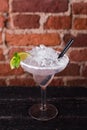 Martini cocktail with ice and lime on a background of a brick wall in a bar Royalty Free Stock Photo