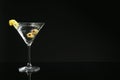 Martini cocktail with olives and lemon twist on dark background, space for text Royalty Free Stock Photo