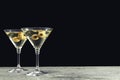 Martini cocktails with olives on grey table against dark background, space for text Royalty Free Stock Photo