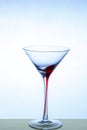 Martini glass on a beautiful long stem with a red accent on a light blue background