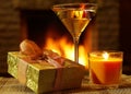 Gift box, martini glass and Candle before fireplace. Royalty Free Stock Photo