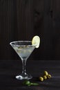 Martini glass with cocktail and olives on black background Royalty Free Stock Photo