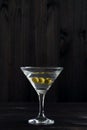 Martini glass with cocktail and olives on black background Royalty Free Stock Photo