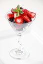 A martini glass full of assorted berries on a white background including strawberries, blackberries, and raspberries Royalty Free Stock Photo