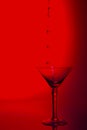 Martini glass high key photo in studio with red tint and water p Royalty Free Stock Photo