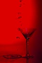 Martini glass high key photo in studio with red tint and water p Royalty Free Stock Photo