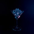 Martini glass with ice cubes in neon holographic vibrant pink and blue colors. Minimal celebration concept Royalty Free Stock Photo