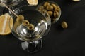 Martini in a glass wineglass with green olives on a skewer on a black table. cocktails. bar Royalty Free Stock Photo