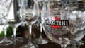 Martini glasses are in the bar. The inscription on the glass and the logo martini sticker. Focus and color concept. A brand of