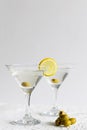 Martini with lemon. Two Martini glasses with cocktail and olives on white background Royalty Free Stock Photo