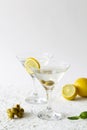 Martini with lemon. Two Martini glasses with cocktail and olives on white background