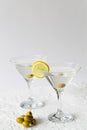 Martini with lemon. Two Martini glasses with cocktail and olives on white background Royalty Free Stock Photo