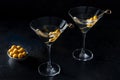 Martini, two glasses with spicy olives on toothpicks, on a black background Royalty Free Stock Photo