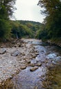 Martvili, Georgia - august 10, 2021: The Abhesi waterfall among green trees, a mountain river with clear water. Tourist place for