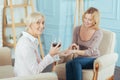 Positive aged woman drinking wine and admiring a beautiful ring