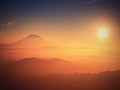 Marvelous daybreak above valley full of colorful mist. Peaks of high trees